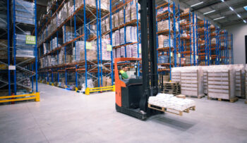 worker-operating-forklift-machine-relocating-goods-large-warehouse-center (1)